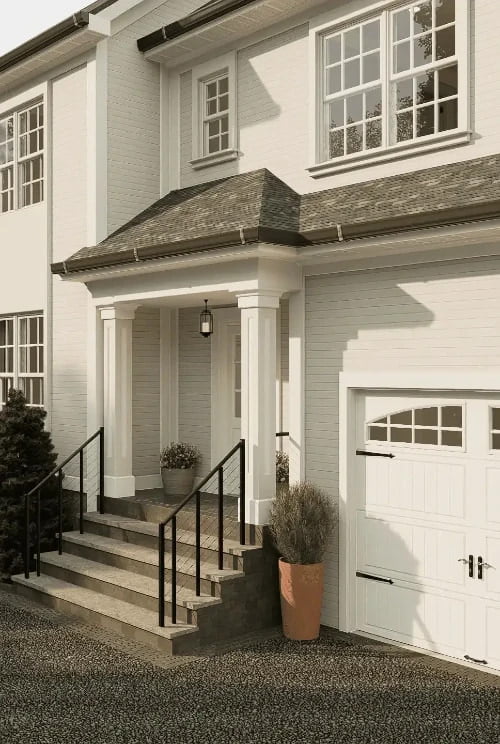 A photorealistic 3D rendering of a two-story family home. The exterior walls are covered in white horizontal siding, complemented by dark roofing. The house features large windows with white frames, a double-hung window above the garage, and an inviting front door with sidelights, all adding to its classic charm. A lantern-style light fixture hangs above the covered entryway, which is accessed by stone steps with a black metal railing. A potted plant next to the steps adds a touch of greenery to the neutral-toned facade.