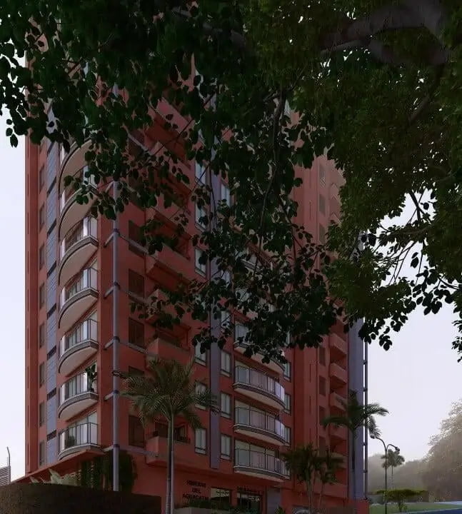 A 3D rendered image of a modern high-rise building located in Cali, Valle del Cauca. The building is characterized by its salmon-colored facade, multiple balconies with glass railings, and external white piping. Palm trees and lush greenery partially obscure the front view, enhancing the urban tropical setting. A sign in the lower part of the image identifies the building as 'Cl. 5d Oe. #15-29, COMUNA 1'. The scene captures a typical foggy or overcast day, adding a moody atmosphere to the urban landscape.